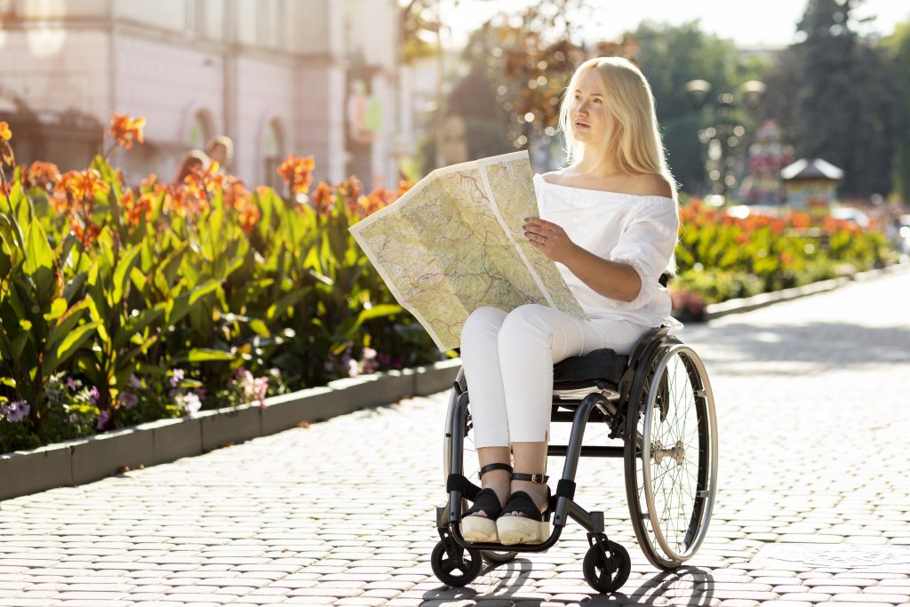 Persona con discapacidad mira en un mapa destinos tras viajar con asistencia